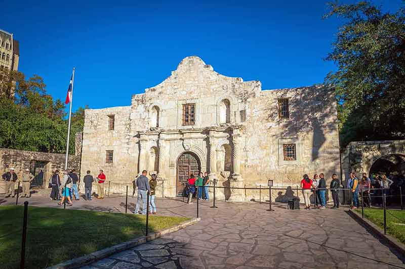 unusual day trips from houston blue sky and people waiting to enter the Alamo
