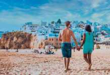Happy Young Couple Walking At The Beach Of Albufeira Algarve