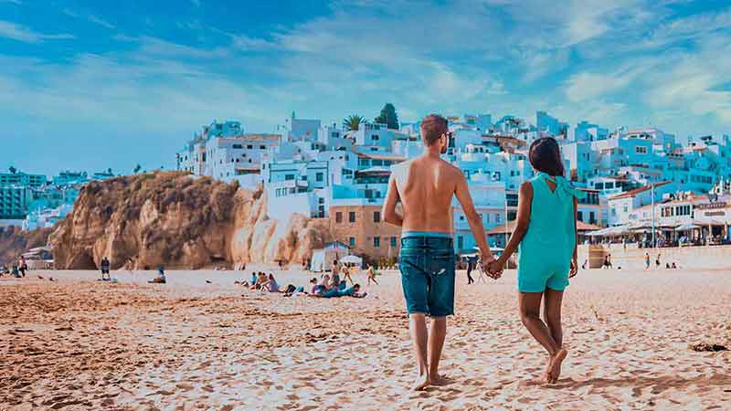 Happy Young Couple Walking At The Beach Of Albufeira Algarve