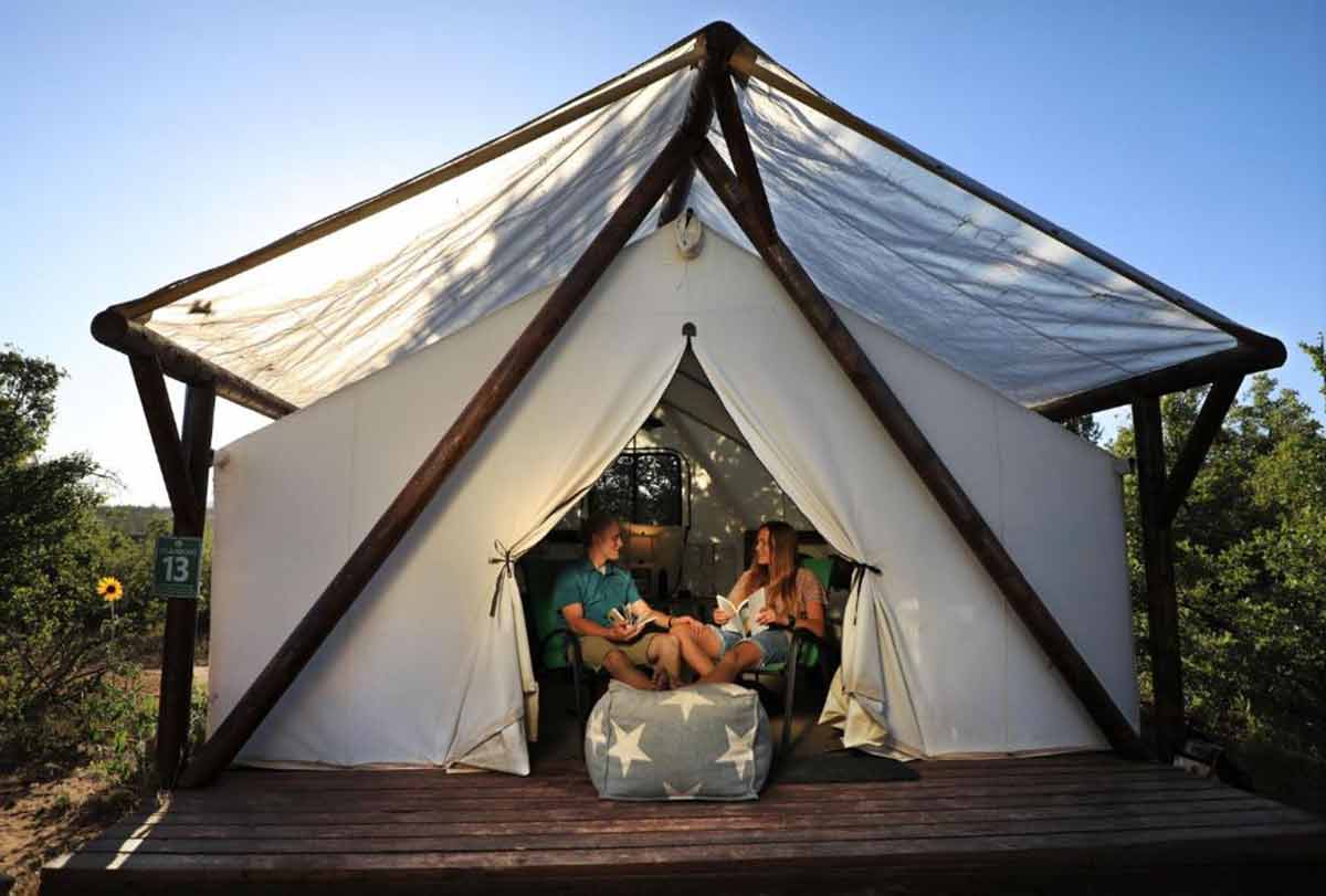 utah glamping Zion Ponderosa couple sitting at the entrance of a white tent