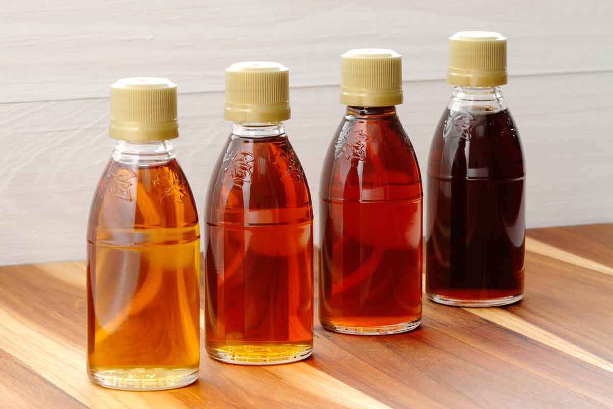 four bottles of maple syrup of different colours