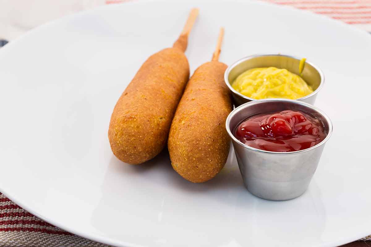 Corn Dogs And Condiments On Plate