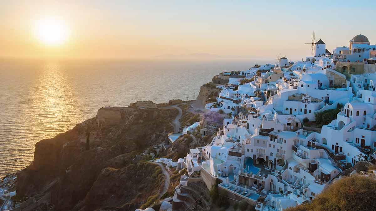 Sunset With White Churches An Blue Domes By The Ocean Of Oia