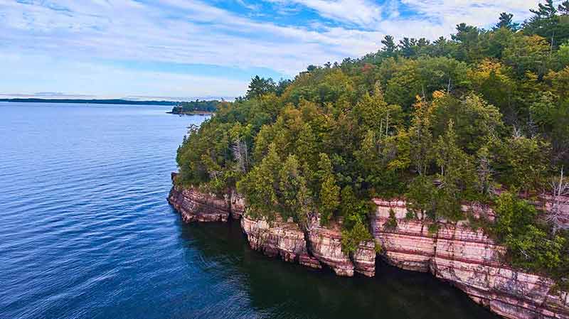 Aerial Over Cliffs On Vermont Coast With Lush Green Forest