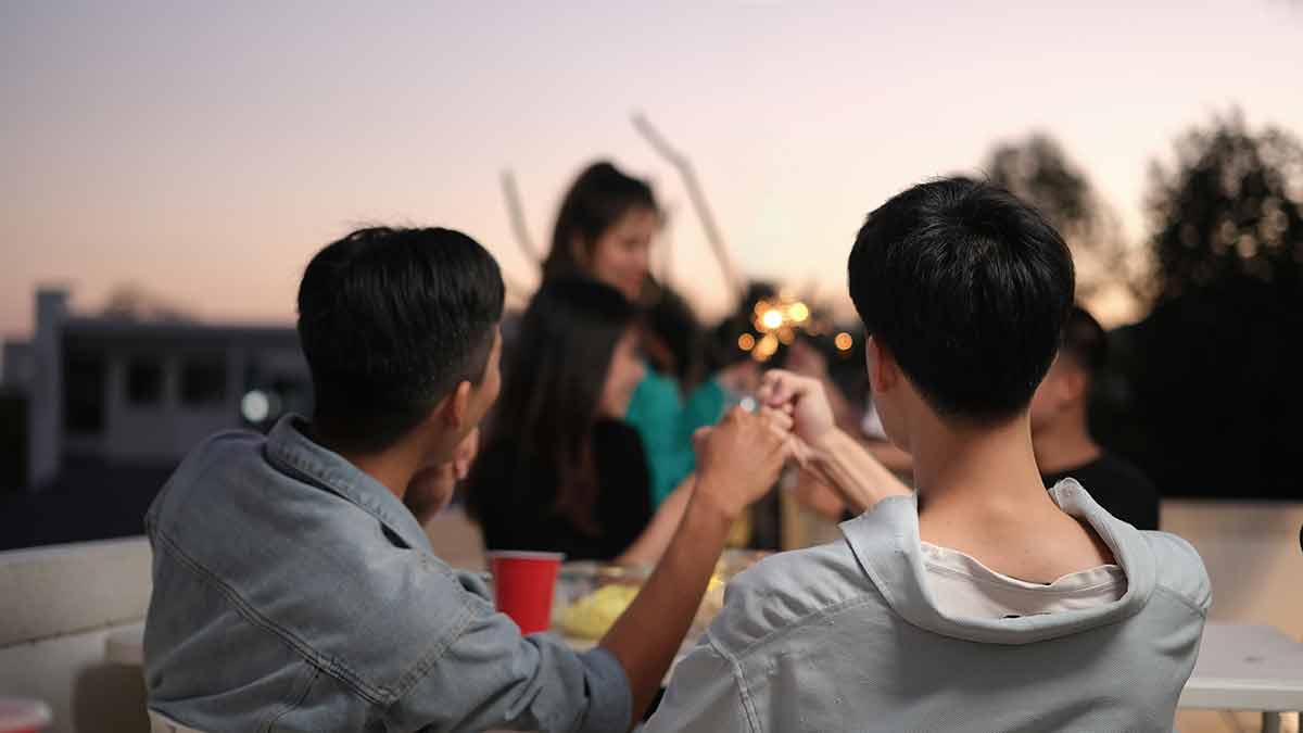 Group Of Friends Taking And Enjoying Drinks During Rooftop Party