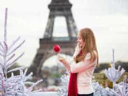 what to wear in winter in paris girl with caramel apple in Paris near the Eiffel Tower.