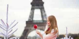 what to wear in winter in paris girl with caramel apple in Paris near the Eiffel Tower.