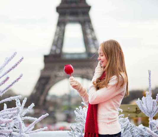 what to wear in winter in paris girl with caramel apple in Paris near the Eiffel Tower.