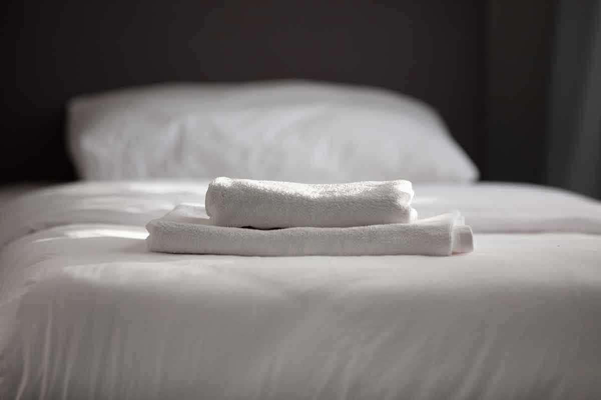 White clean towels stacked on the hotel bed