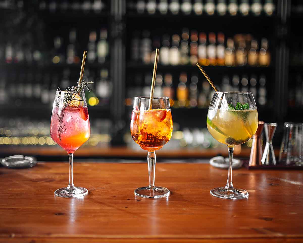 Glasses Of Different Fruit Cocktails On Bar Desk