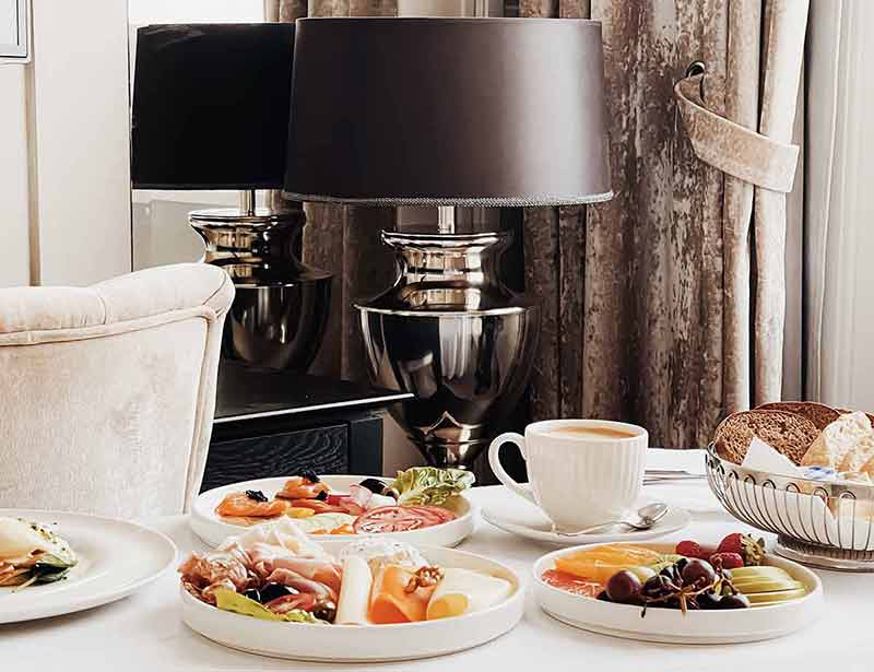 Luxury hotel and five star room service, various food platters, bread and coffee as in-room breakfast for travel and hospitality brand.