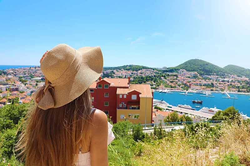 Europe travel woman looking at Dubrovnik town from viewpoint