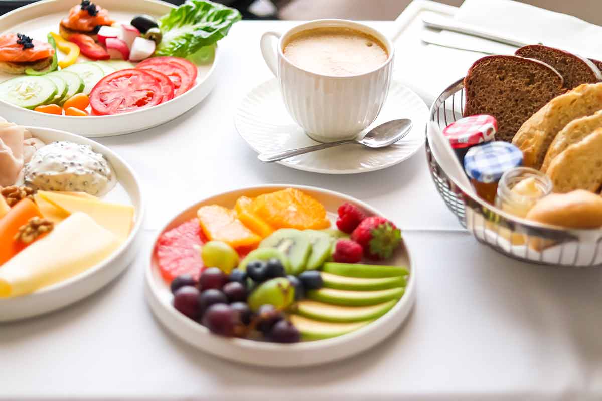various food platters, bread and coffee as in-room breakfast