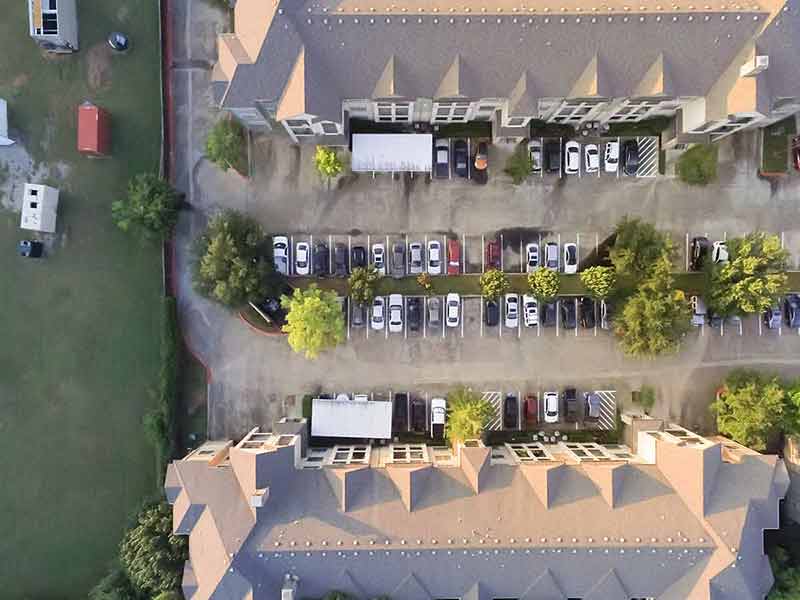 Top view apartment building complex near vacant land with containers at sunset in Houston, Texas,