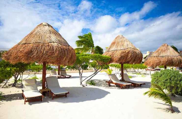 20 of Tulum’s Hottest Hotels Right Now (And the One Celebs Keep Booking) where to stay in tulum beach chaise lounges under an umbrella on sandy beach